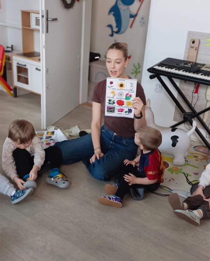 Teta ukazuje dětem obrázky jarních květin